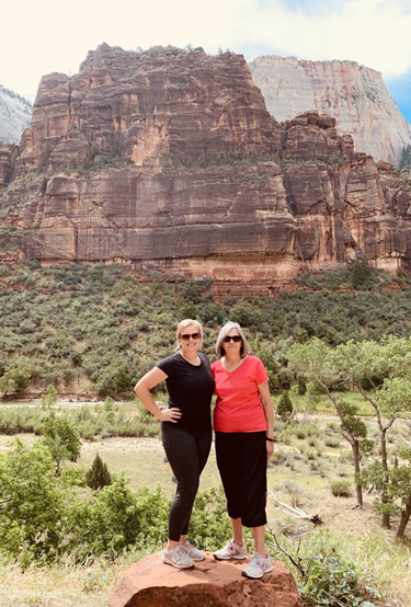 people infront of cliff formation at zion